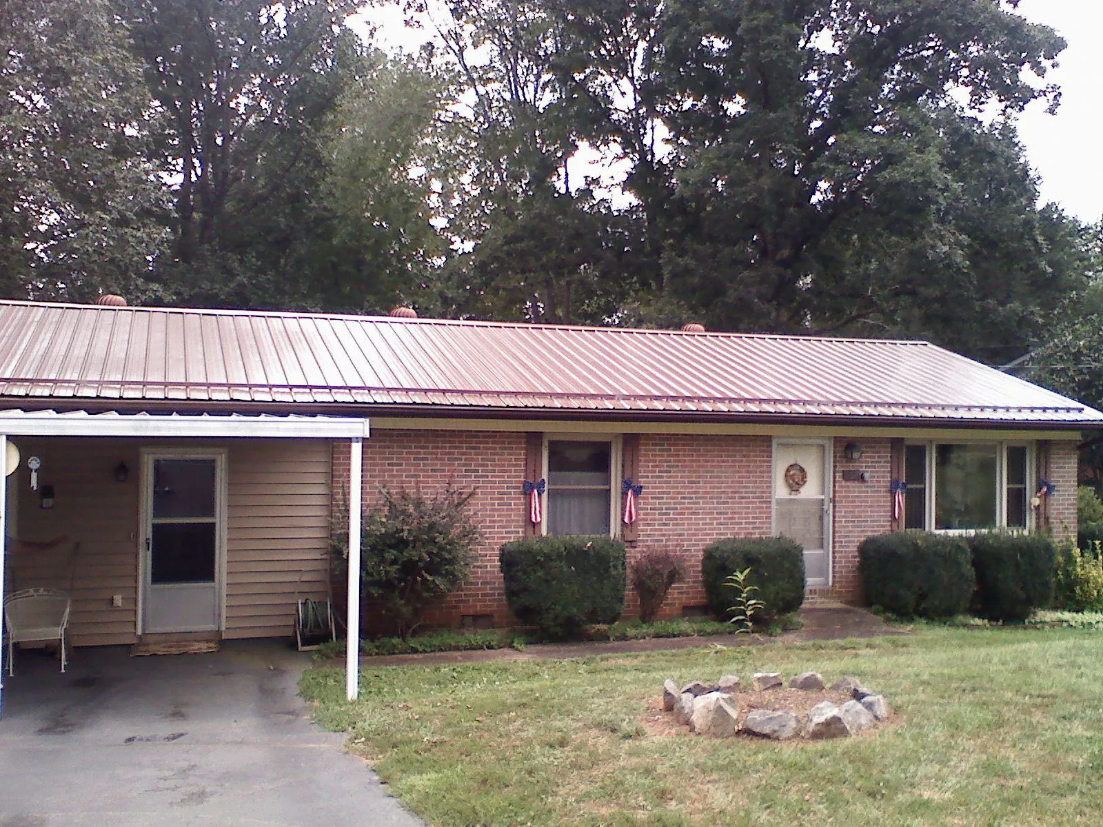 Bronze metal roof and carport on a brick ranch home — Roof Repair work by our crew in Lacrosse